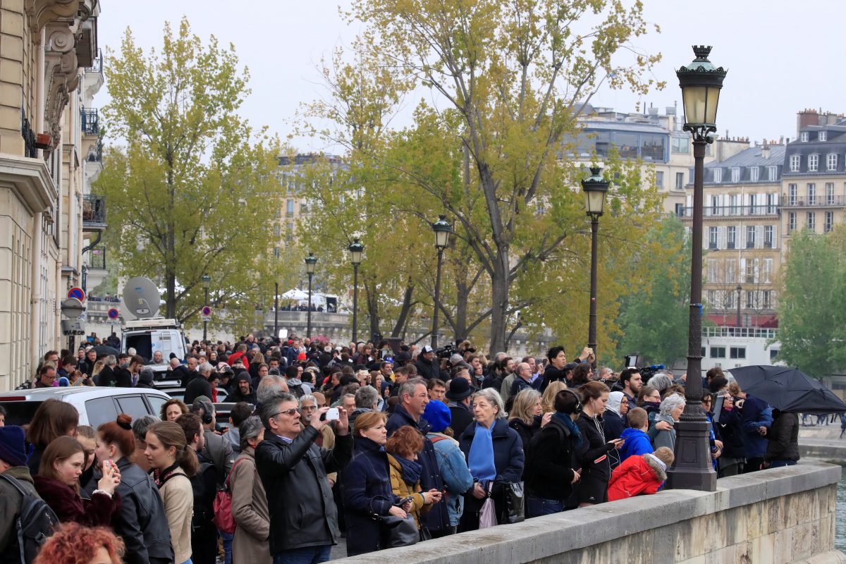 People look at Notre-Dame Cathedral after a massive fire devastated large parts of the gothic gem in Paris