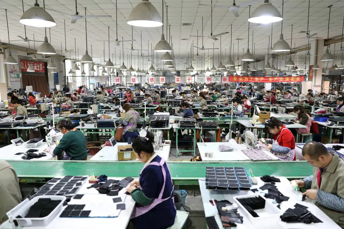 Employees work on the production line of a factory manufacturing fashion accessories in Sihong County, Jiangsu Province, China on March 27, 2019. (Reuters)