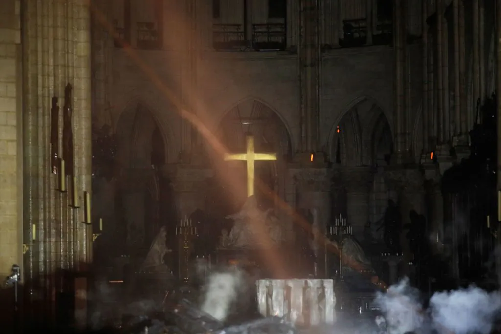 Smoke rises around the alter in front of the cross inside the Notre-Dame Cathedral as the fire continues to burn in Paris on April 16, 2019. (Philippe Wojazer/AFP/Getty Images)