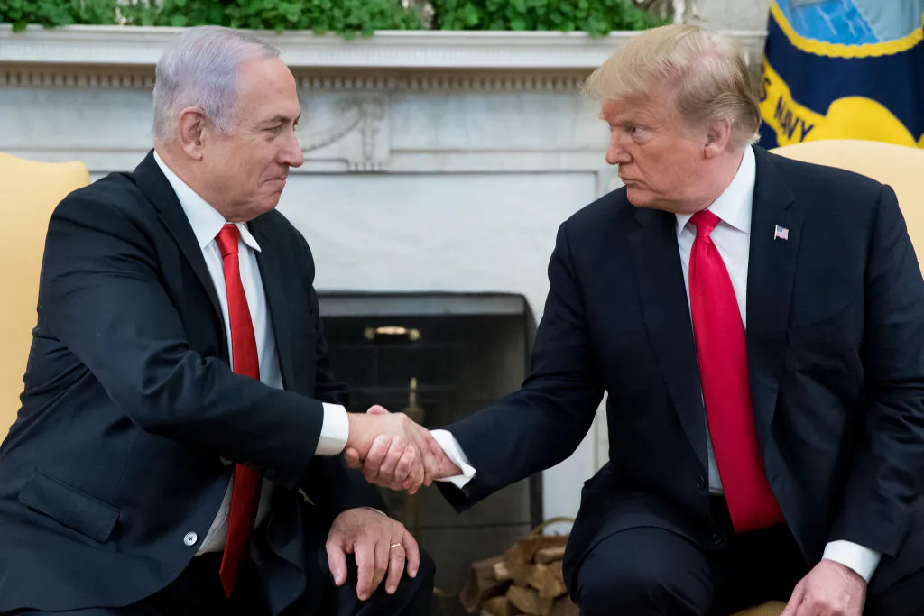 U.S. President Donald Trump (R) and Israeli Prime Minister Benjamin Netanyahu (L) shake hands in the Oval Office of the White House on March 25, 2019. (Michael Reynolds - Pool/Getty Images)