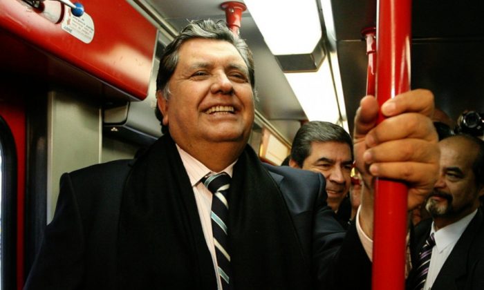 Peru's outgoing President Alan Garcia ride the soon to be inaugurated Line 1 electrical train system in Lima, Peru, on July 11, 2011. (Martin Mejia/File via AP)