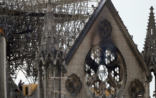 A worker checks on a wooden support structure placed on the Notre Dame Cathedral in Paris