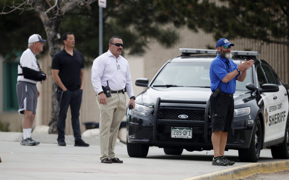 School police officers look on as students leave Columbine High School