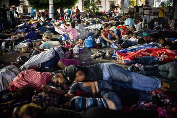 Central American migrants heading in caravan to the US rest during a stop