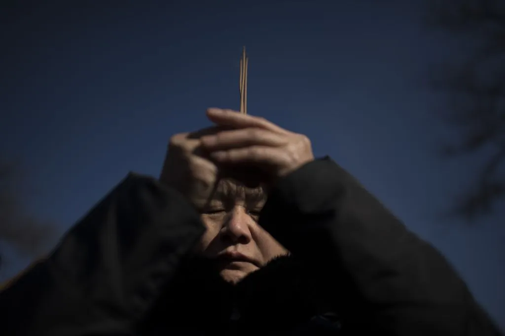 A woman prays with incense sticks to celebrate the Lunar New Year, at the Lama temple in Beijing on Feb. 16, 2018. (Nicolas Asfouri/AFP/Getty Images)