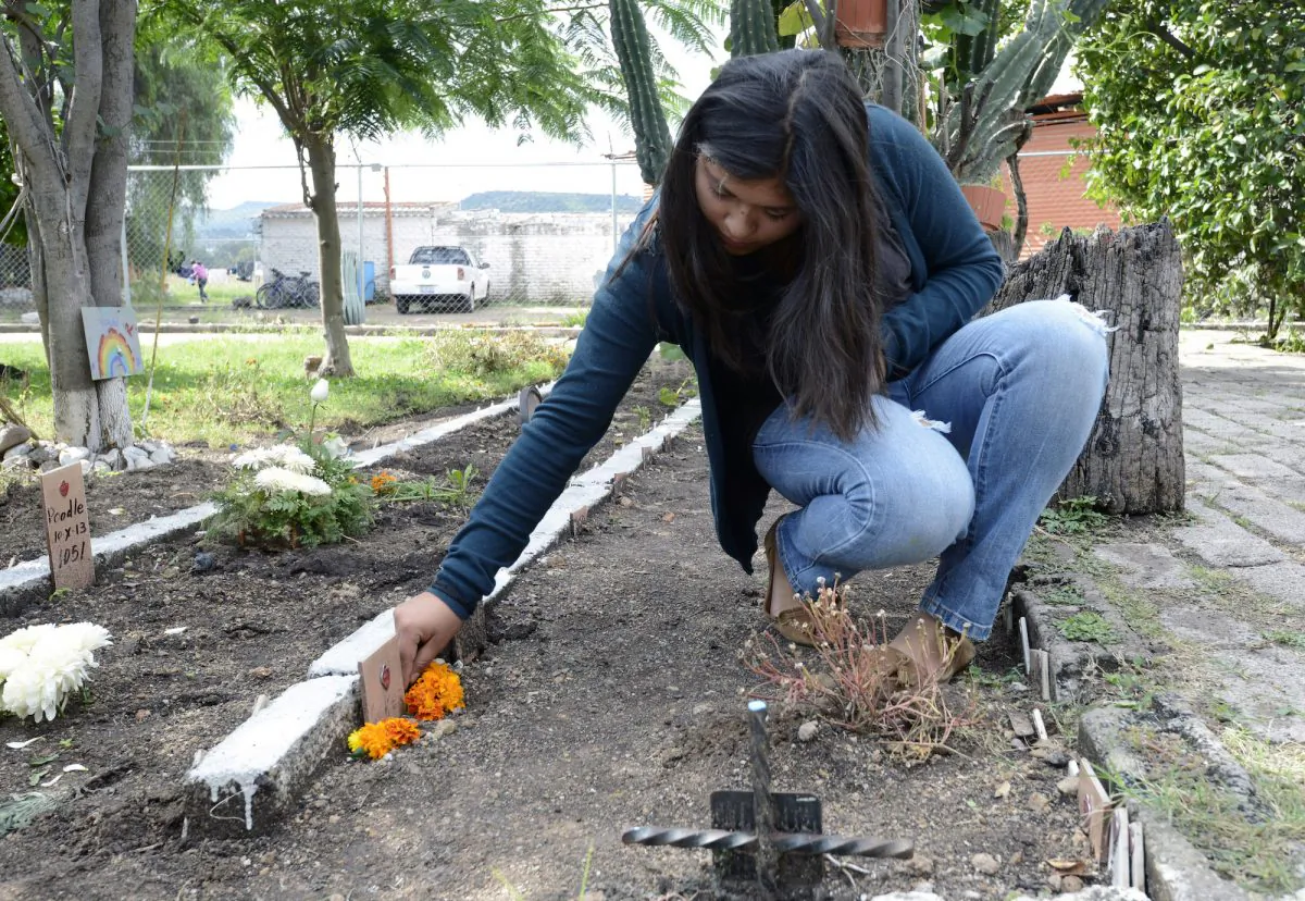 FILE—A woman puts flowers on her dog's grave at the pet cemetery in Corregidora, Mexico, in November 2013. (Alfredo Estrella/AFP/Getty Images)