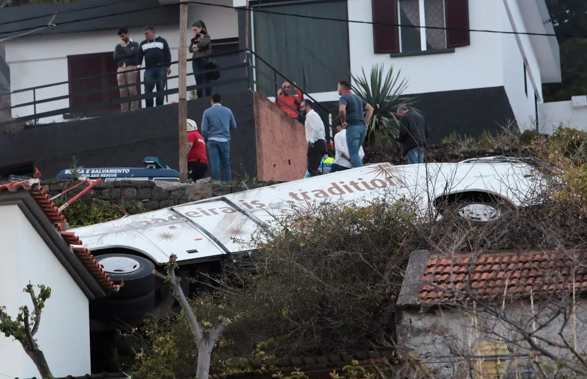 People stand next to the wreckage of a bus after an accident in Canico, in the Portuguese Island of Madeira, April 17, 2019. (Duarte Sa/Reuters)
