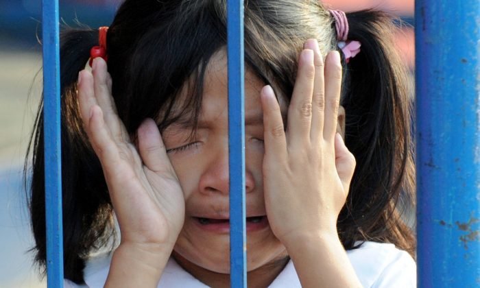 A girl crying behind a fence. (JAY DIRECTO/AFP/Getty Images)