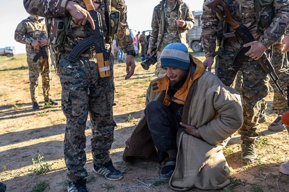 A man from Bosnia suspected of being an ISIS fighter is searched by members of the Kurdish-led Syrian Democratic Forces (SDF) after leaving the IS group's last holdout of Baghouz, in Syria's northern Deir Ezzor province on March 1, 2019. (Bulent Kilic/AFP/Getty Images)
