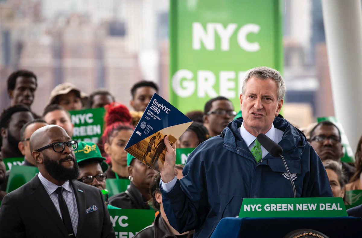 New York City Mayor Bill de Blasio holds up a copy of 'One NYC 2050' as he speaks about the city's response to climate change at Hunters Point South Park in the Queens borough of New York City on April 22, 2019. (Drew Angerer/Getty Images)