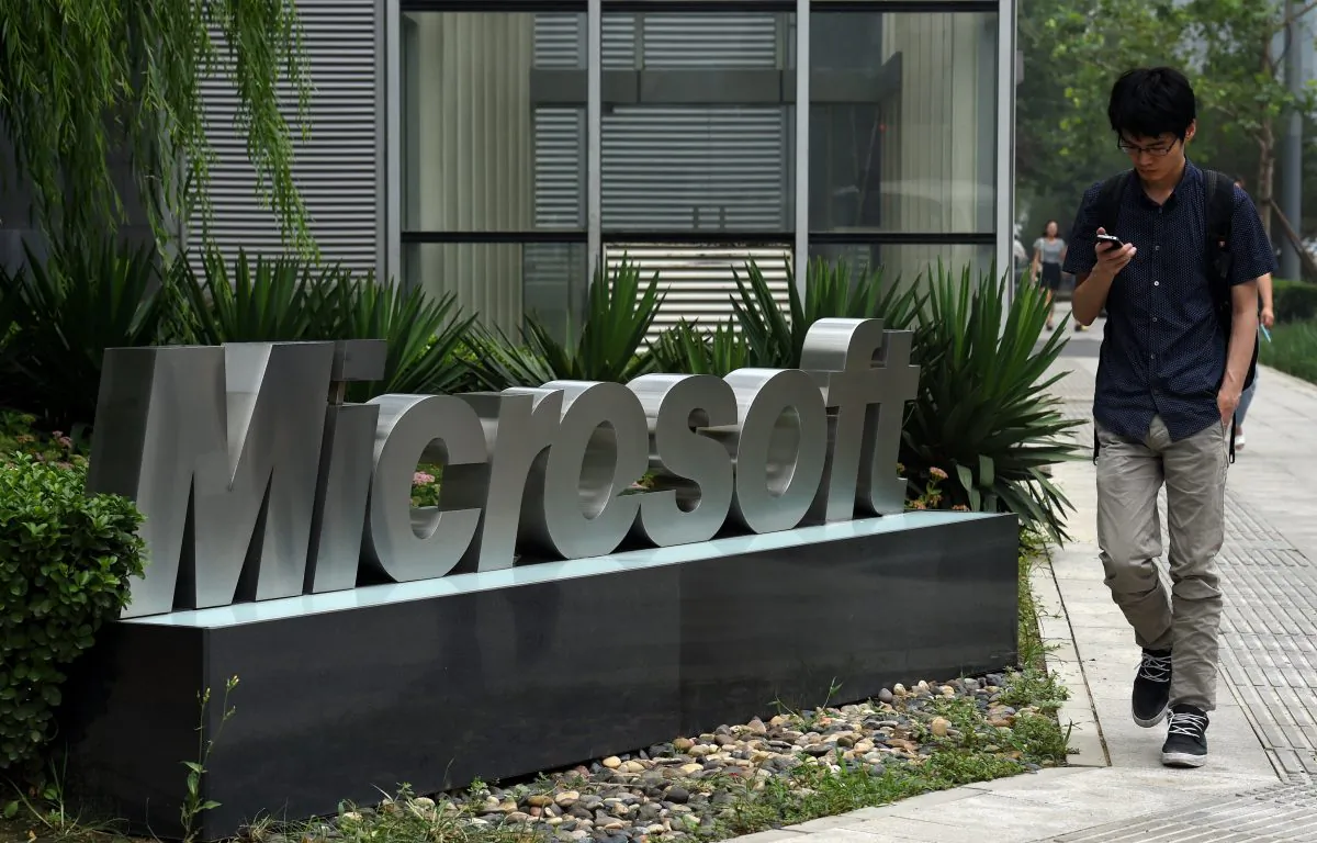 A man walks past a Microsoft sign outside a Microsoft office building in Beijing on July 31, 2014. (Greg Baker/AFP/Getty Images)