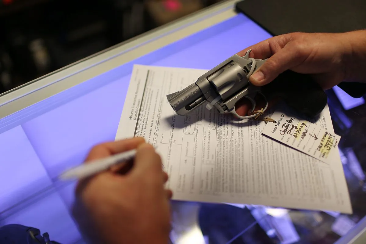 A customer fills out his federal background check paperwork as he purchases a handgun in Delray Beach, Fla., on Jan. 5, 2016. (Joe Raedle/Getty Images)