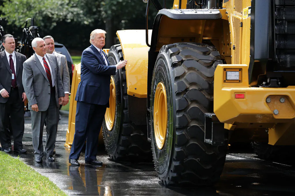 U.S. President Donald Trump touches a wheel loader made by Caterpillar while touring a Made in America product showcase with Vice-President Mike Pence on the South Lawn of the White House in Washington on July 17, 2017 (Chip Somodevilla/Getty Images)