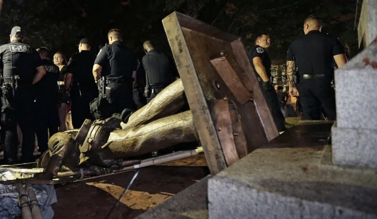 Police stand guard after the Confederate statue known as Silent Sam was toppled by protesters on campus at the University of North Carolina in Chapel Hill, N.C. ,on Aug.20, 2018. (Gerry Broome, AP Photo/File)