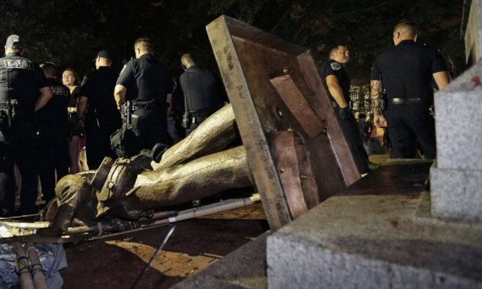 Police stand guard after the Confederate statue known as Silent Sam was toppled by protesters on campus at the University of North Carolina in Chapel Hill, N.C. ,on Aug.20, 2018. (Gerry Broome, AP Photo/File)