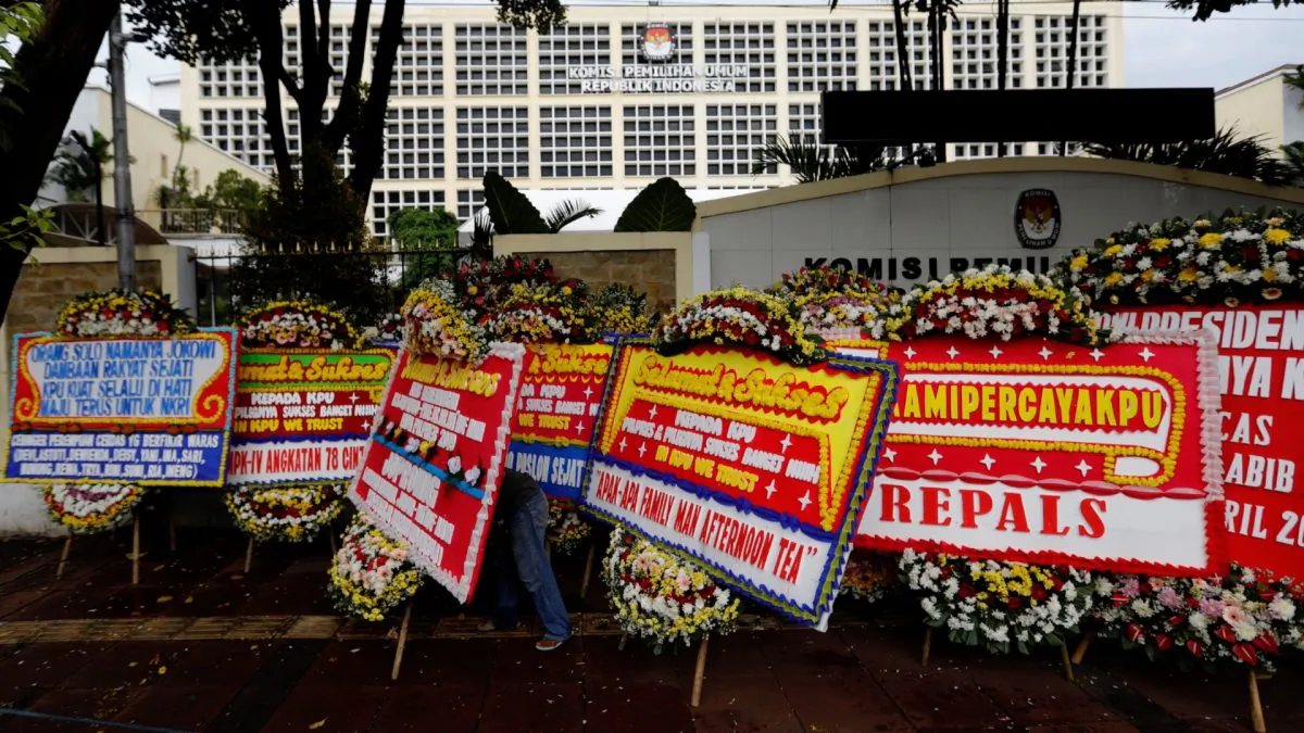 A worker arranges flower wreaths and congratulatory boards from people after this week's election outside General Election Commission (KPU) headquarters in Jakarta, Indonesia on April 21, 2019. (Willy Kurniawan/Reuters)