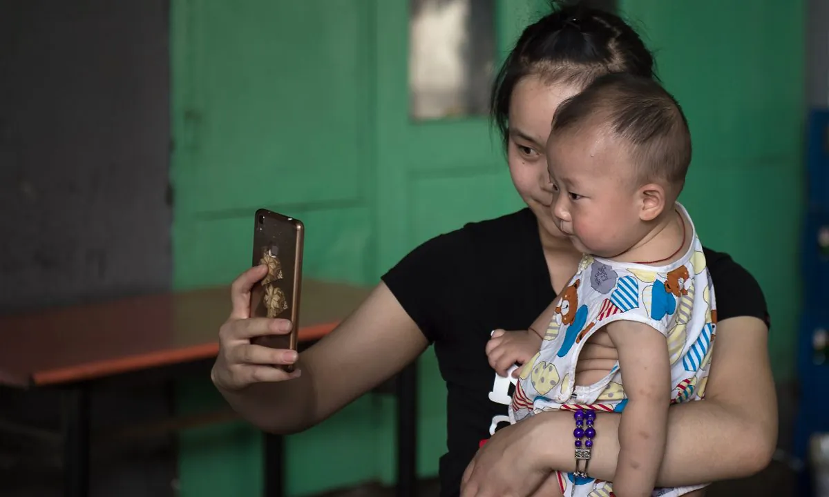 A woman taking a photo of herself with her baby. (Nicolas Asfouri/AFP/Getty Images)