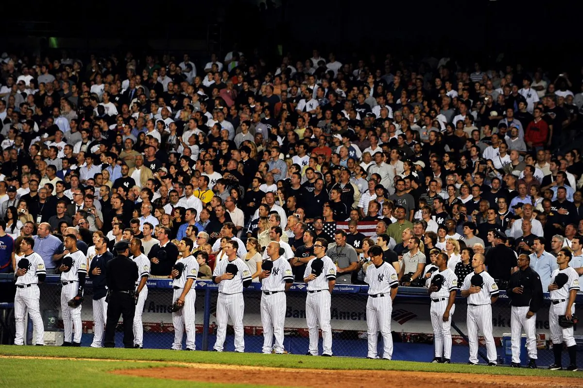 The New York Yankees stand at attention as God Bless America is sung during the seventh inning stretch at the last regular season game at Yankee Stadium on September 21, 2008 in the Bronx borough of New York City. Al Bello/Getty Images