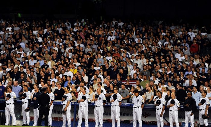The New York Yankees stand at attention as God Bless America is sung during the seventh inning stretch at the last regular season game at Yankee Stadium on September 21, 2008 in the Bronx borough of New York City. Al Bello/Getty Images