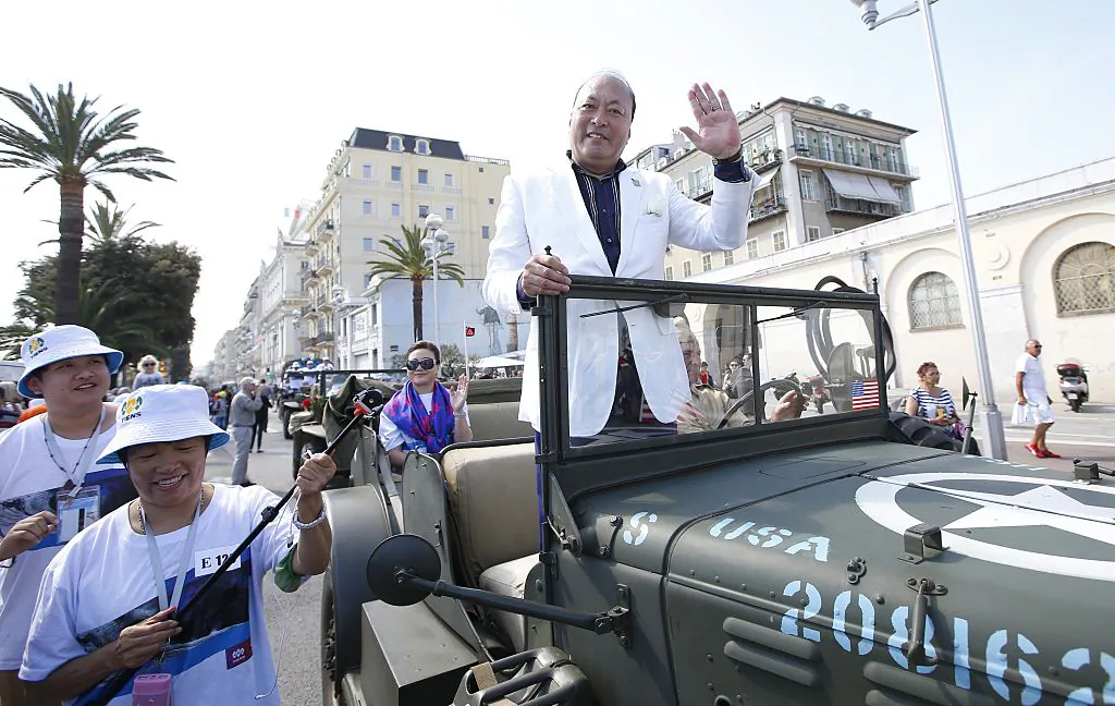 Chinese businessman and CEO Tiens Group, Li Jinyuan (C), parades in Nice as part of a celebration for the 20th anniversary of his company, on May 8, 2015. His company was revealed to be running a pyramid scheme. (VALERY HACHE/AFP/Getty Images)