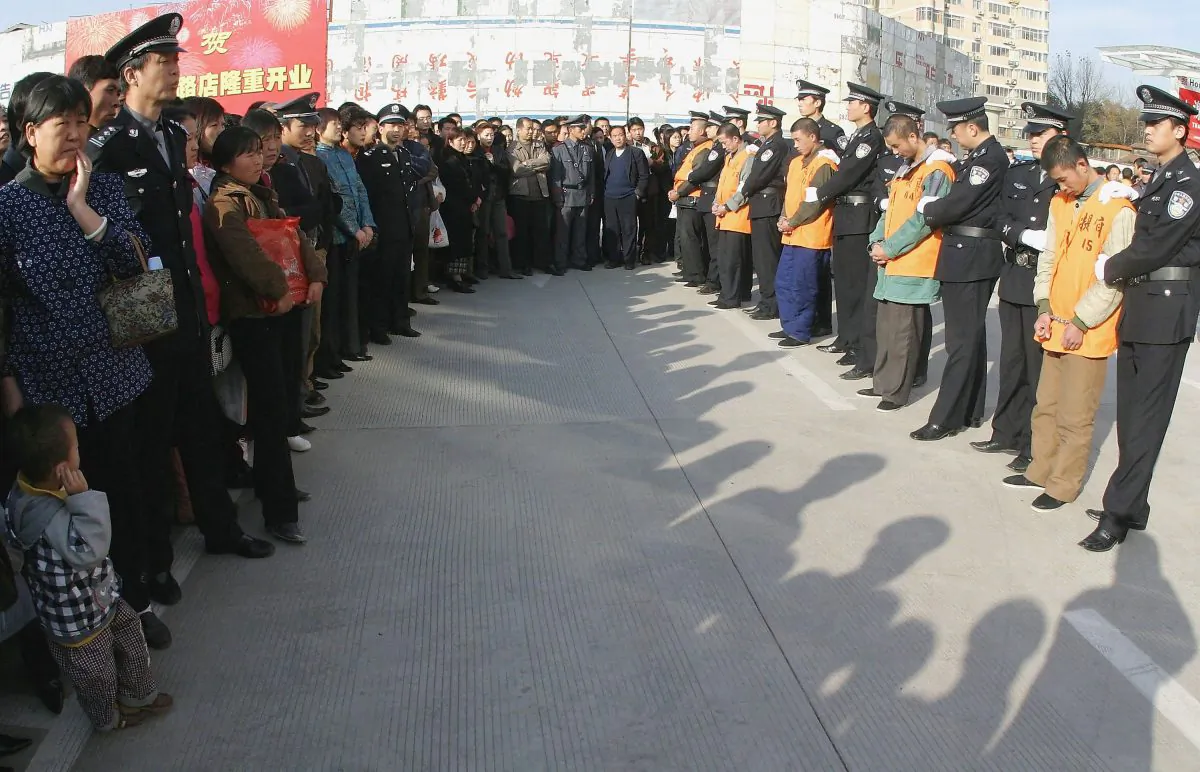 Chinese police parade a group of 15 convicted criminals to be sentenced in public, most of which are likely to face the death penalty, on November 15, 2004 in Xian, China. (China Photos/Getty Images)