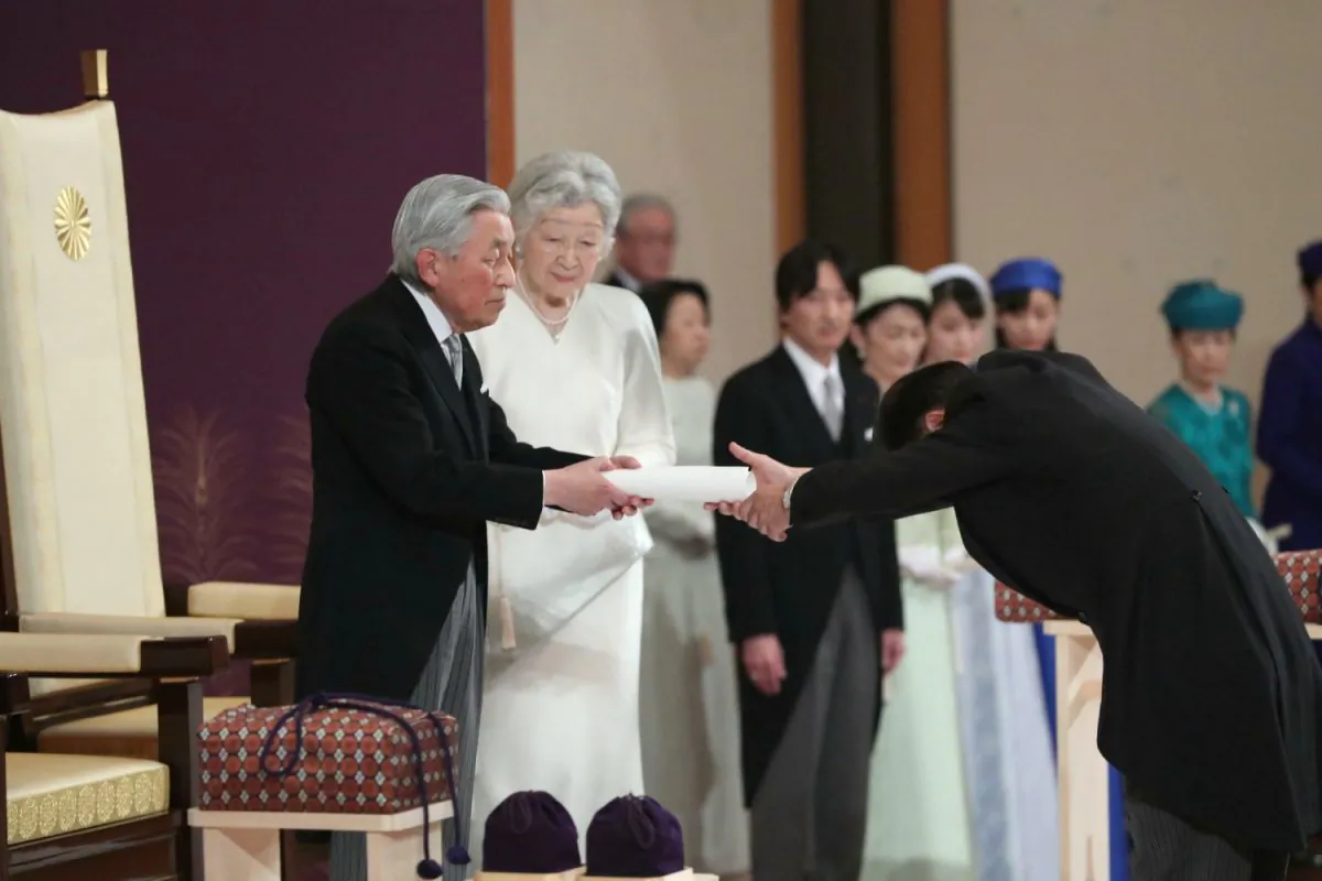 Japan's head of state Akihito hands over his statement to the grand chamberlain during the ceremony of his abdication at the Imperial Palace in Tokyo, Tuesday, April 30, 2019. The 85-year-old Akihito ends his three-decade reign on Tuesday. (Japan Pool via The Associated Press)