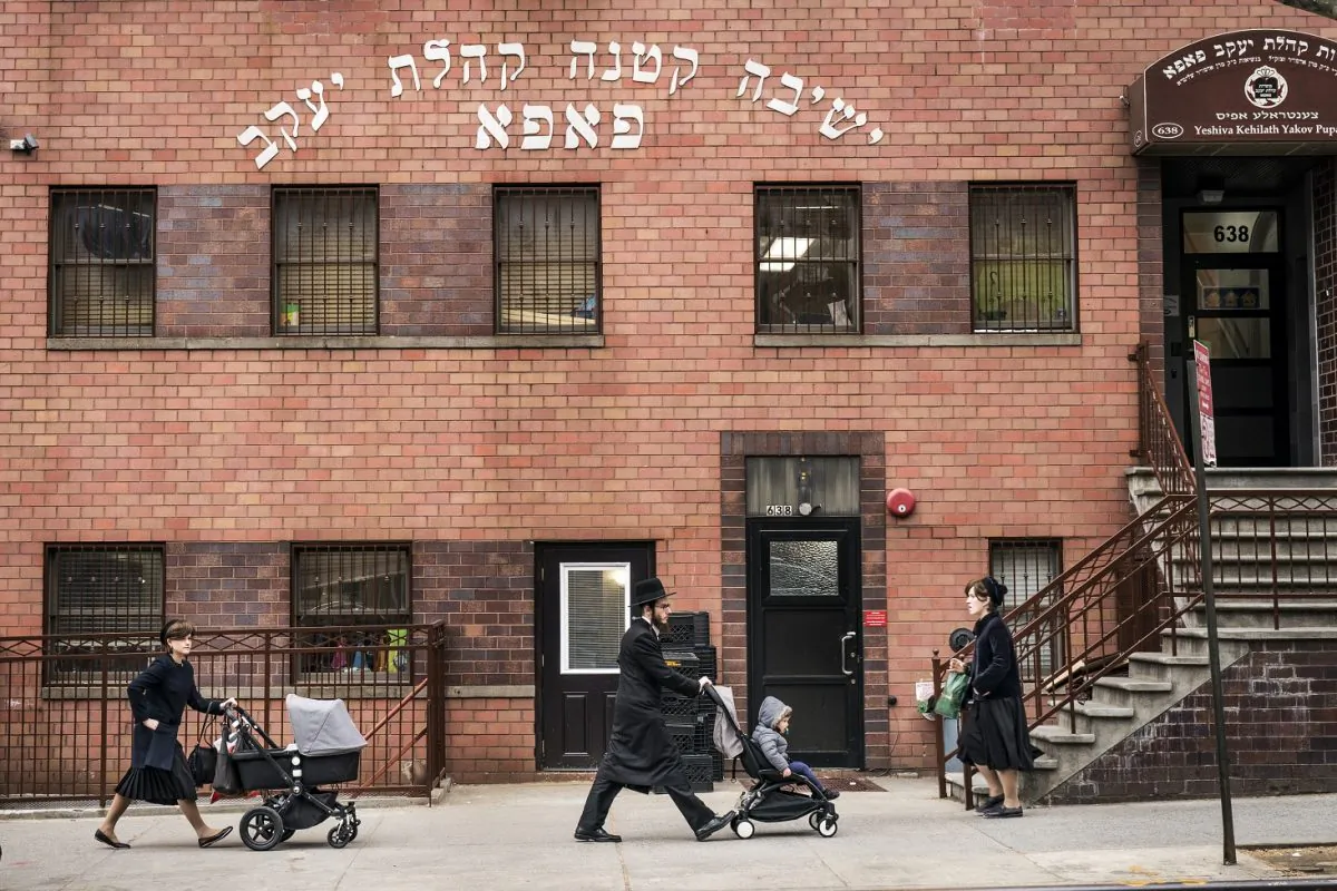 Pedestrians walk past the Yeshiva Kehilath Yakov School in the Williamsburg neighborhood of Brooklyn, N.Y., on April 9, 2019. (Drew Angerer/Getty Image)