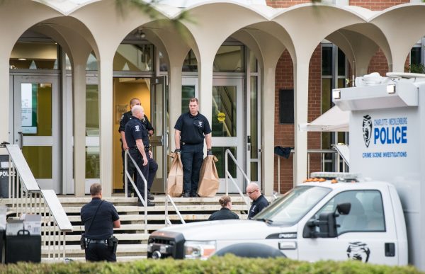 Charlotte-Mecklenburg law enforcement stand in front of the Kennedy building where a gunman killed two people and injured four students at UNC Charlotte in Charlotte