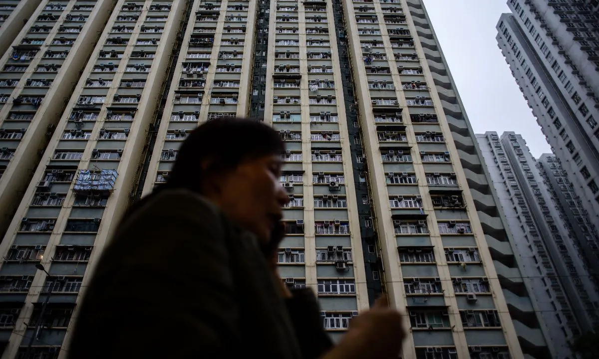 A woman talks on the phone in front of a high rise residential building in a file photo. (Anthony Wallace/AFP/Getty Images