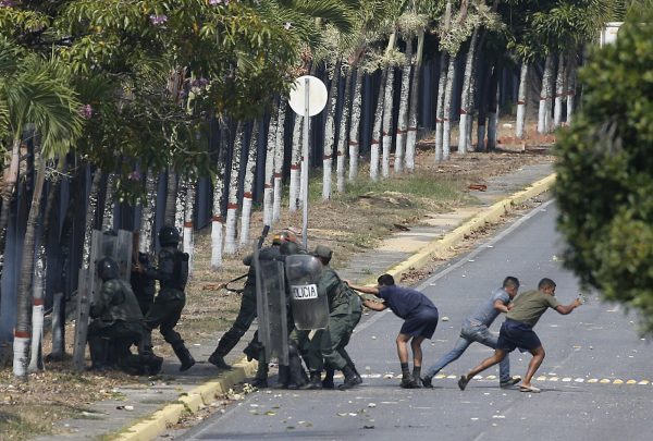 Security forces, some in civilian clothing, take positions inside La Carlota airbase