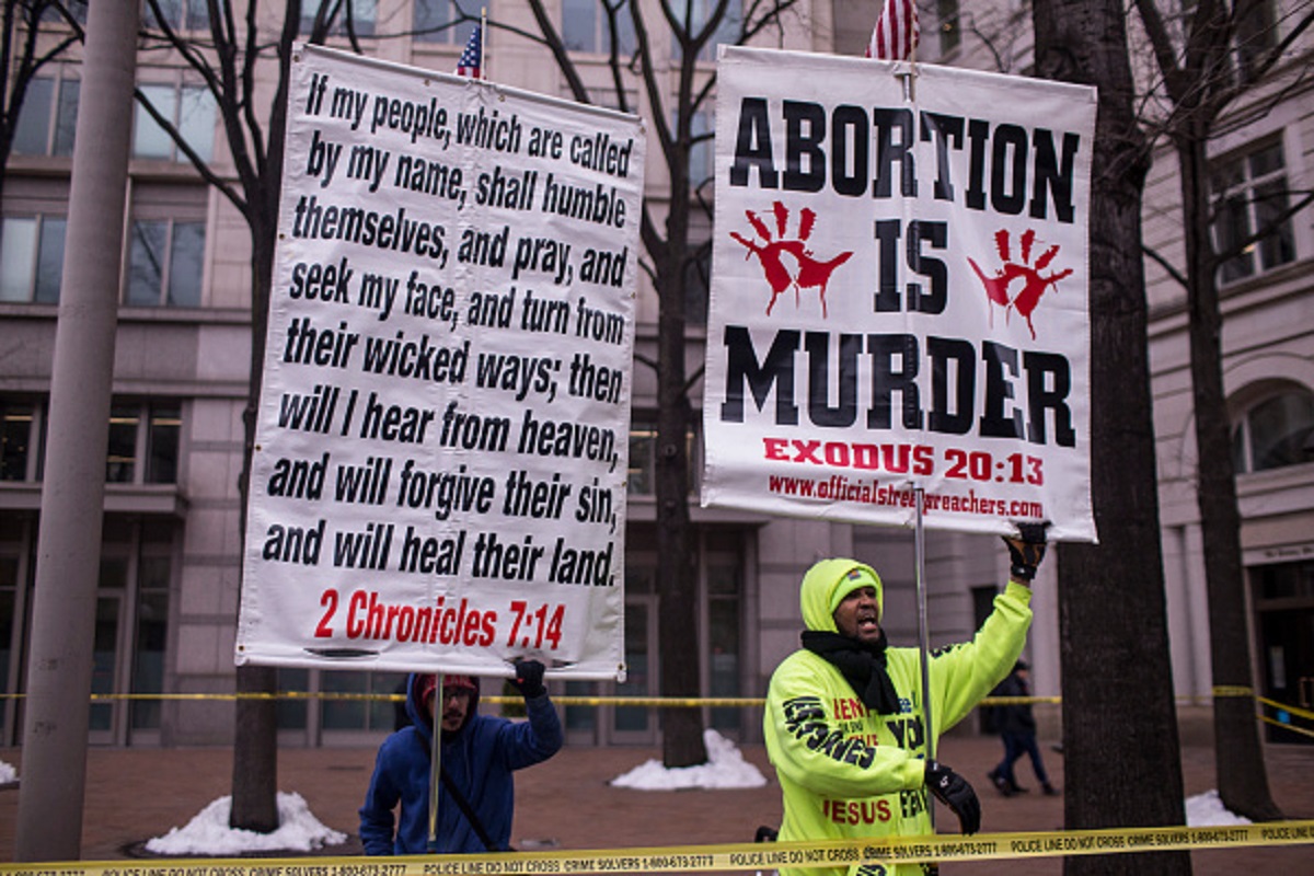 Anti-abortion protestors hold signs near Freedom Plaza