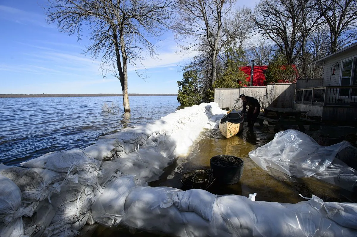 A resident of Fitzroy Harbour, Ont., work to hold back flood waters on the Ottawa River on April 29, 2019. (Sean Kilpatrick/The Canadian Press)