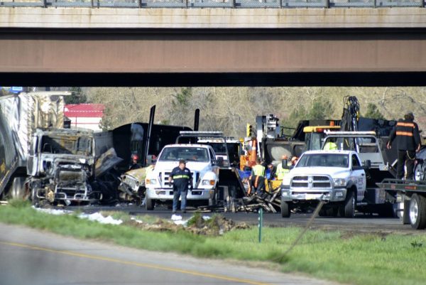 Authorities survey the scene of a fiery crash on I-70