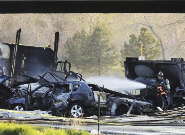 A firefighter sprays water on the wreckage in Lakewood, Colo.,