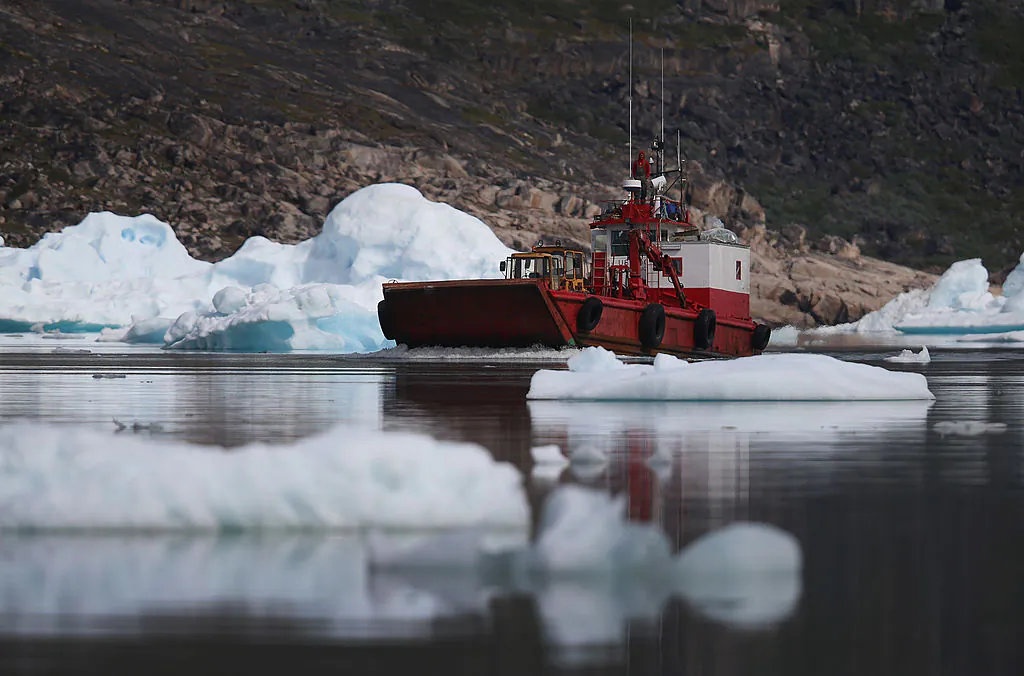 A boat navigates among calved icebergs from the nearby Twin Glaciers in Qaqortoq, Greenland, on July 21, 2013. (Joe Raedle/Getty Images)