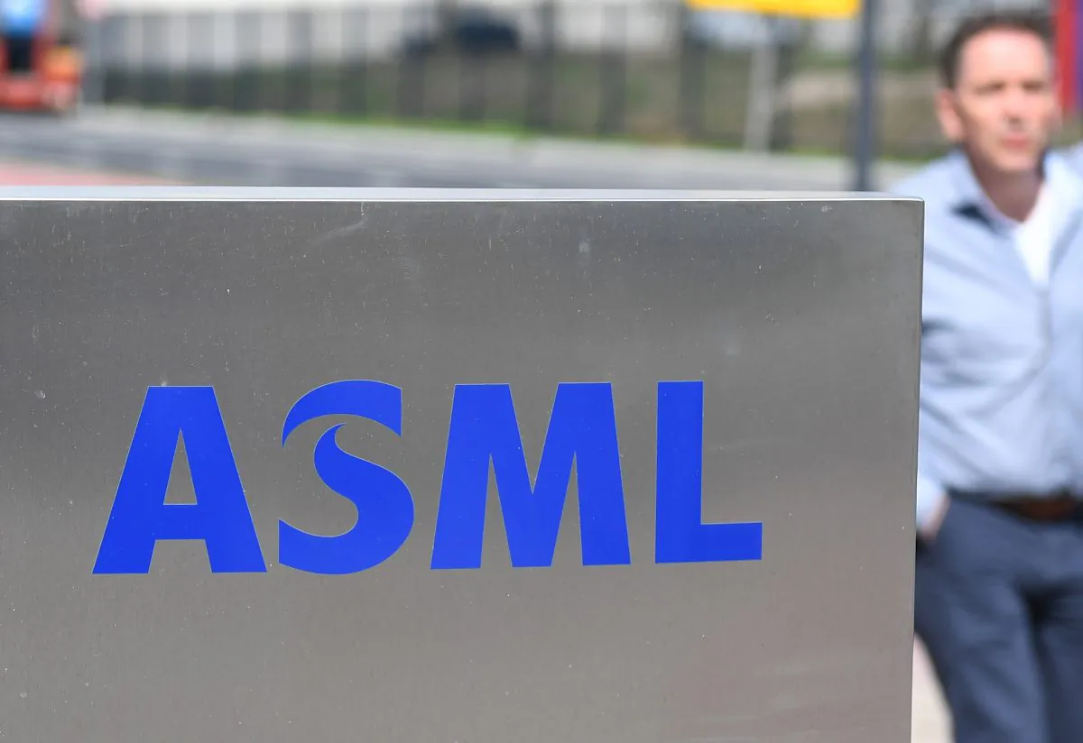 An employee walks past an ASML logo, a Dutch company which is currently the largest supplier in the world of semiconductor manufacturing machines, at the company's headquarters in Veldhoven on April 17, 2018. (EMMANUEL DUNAND/AFP/Getty Images)