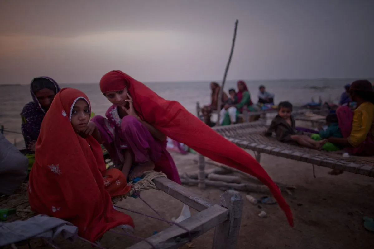 Young girls, whose families were displaced by floods, sit on a makeshift bed, as they take shelter on higher ground in Thatta, Pakistan on Aug. 29, 2010. (Daniel Berehulak/Getty Images)