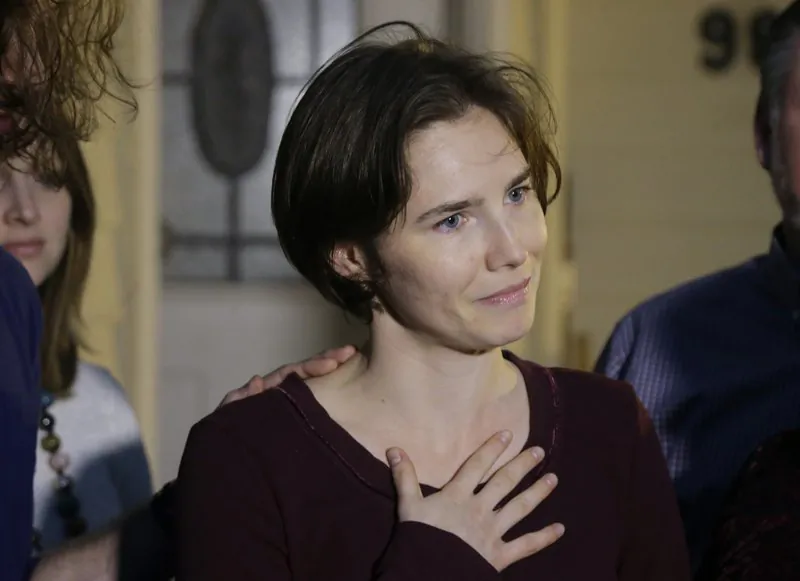 File photo showing Amanda Knox talking to reporters outside her mother's home, in Seattle, on March 27, 2015. Knox says she is returning to Italy for the first time since she was convicted and imprisoned, but ultimately acquitted, for the murder and sexual assault of her British roommate Meredith Kercher, in the university hilltop town of Perugia. (Ted S. Warren/AP Photo)
