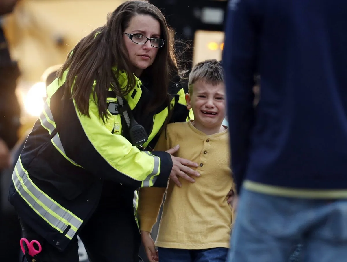Officials guide students off a bus and into a recreation center where they were reunited with their parents after a shooting at a suburban Denver middle school in Highlands Ranch, Colo., on May 7, 2019. (David Zalubowski/AP Photo)