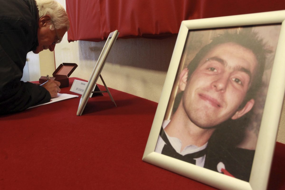 A man signs condolence books in memory of Antoine de Leocour and Vincent Delory at Linselles' city hall, northern France