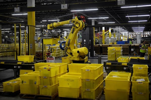 A 6-axis robotic arm picks up sorting containers at the Amazon fulfillment center