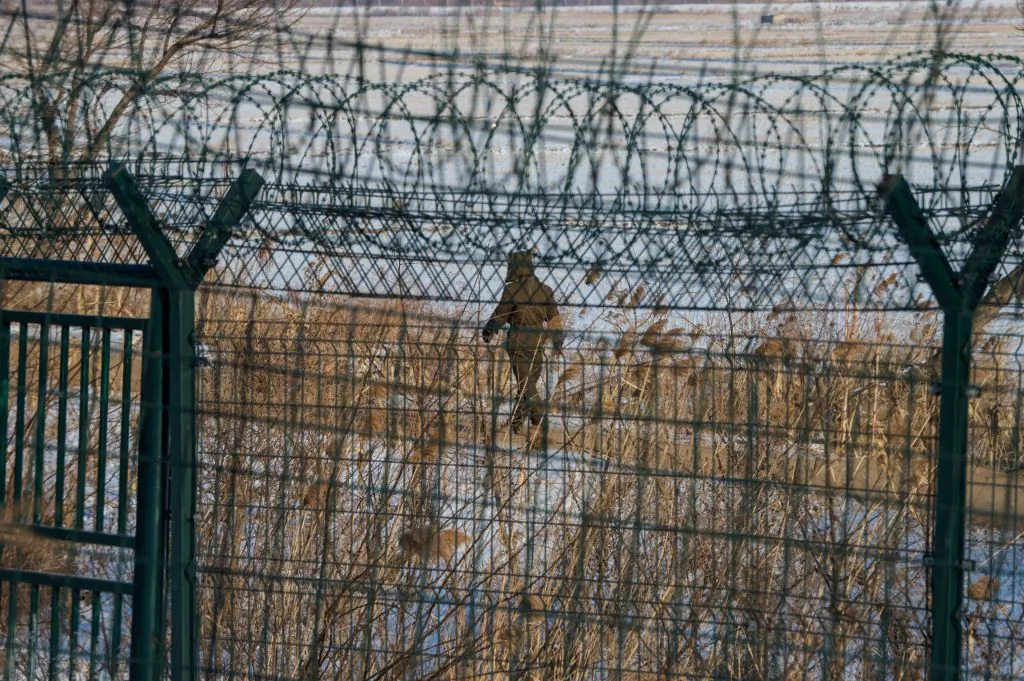 A North Korean soldier walks along the border fence of North Korean town of Sinuiju opposite the Chinese border city of Dandong in northeast China's northeast Liaoning Province, on Jan. 10, 2018. (Chandan Khanna/AFP/Getty Images)