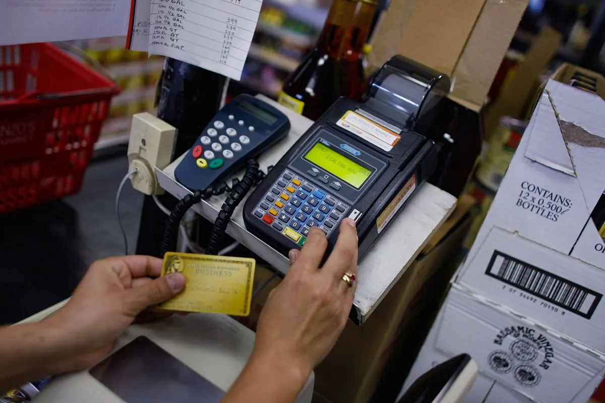 Yera Dominguez uses a credit card reader to charge a credit card from a customer for payment at Lorenzo's Italian Market in Miama, Fla., on May 20, 2009. Joe Raedle/Getty Images