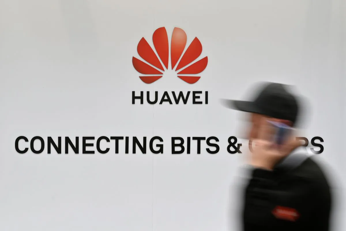 A visitor walks past the logo of Chinese telecom giant Huawei at the Hanover Messe technology fair on April 1, 2019, in Hanover Germany. (John MacDougall/AFP/Getty Images)