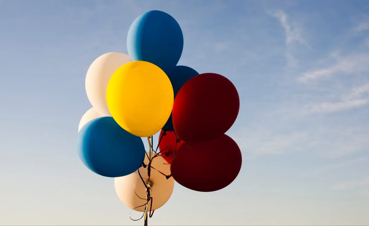 A bunch of helium-filled balloons float in the air. There is a current world shortage of helium, which is putting strain on some businesses and scientific research. (Andreas Weiland/Unsplash)