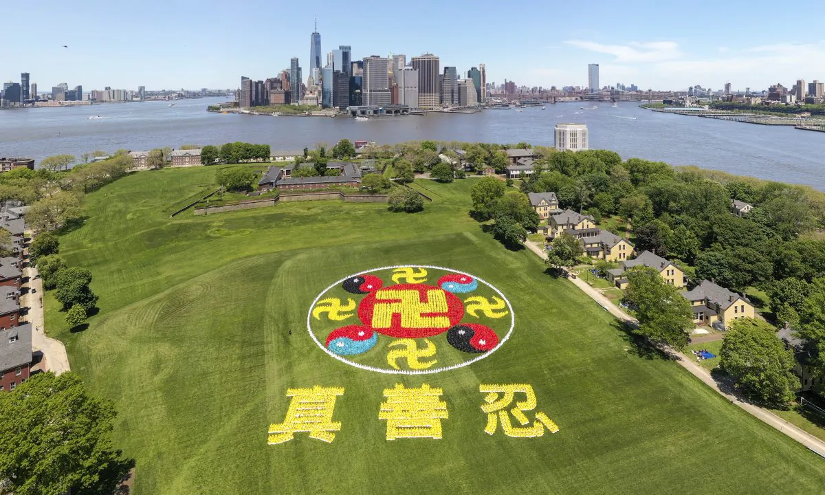 Thousands of Falun Gong practitioners came together on New York City's Governors Island for the character formation event on May 18, 2019. The emblem consists of ancient symbols, the yellow srivatsa symbolizing Buddhism and the red-black and red-blue Taiji symbols representing Taoism. (NTD) 