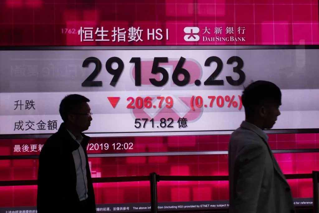 Pedestrians walk in front of a stock display board that shows the Hang Seng Index in Hong Kong on May 8, 2019 (PHILIP FONG/AFP/Getty Images)