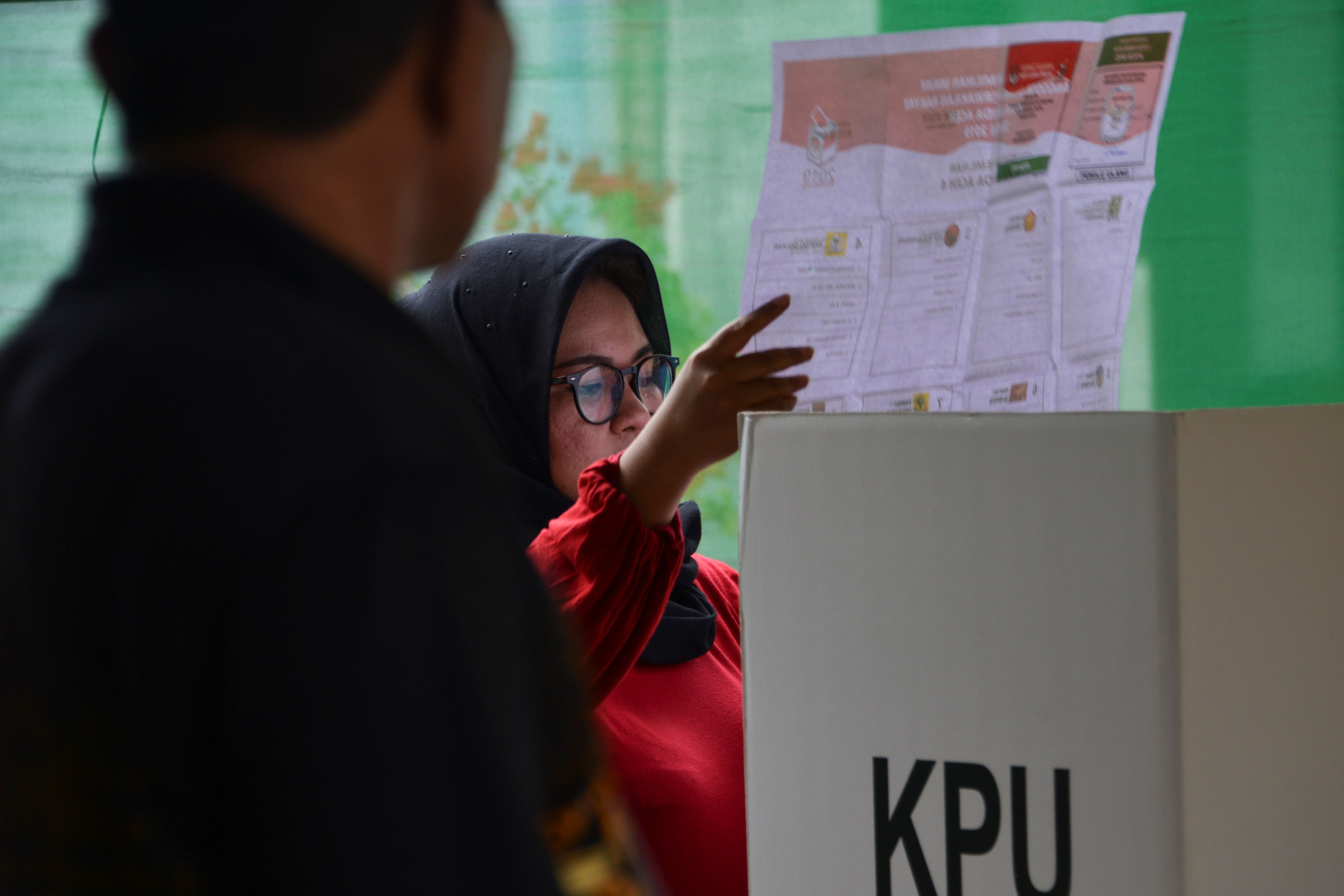 A woman looks at her ballot