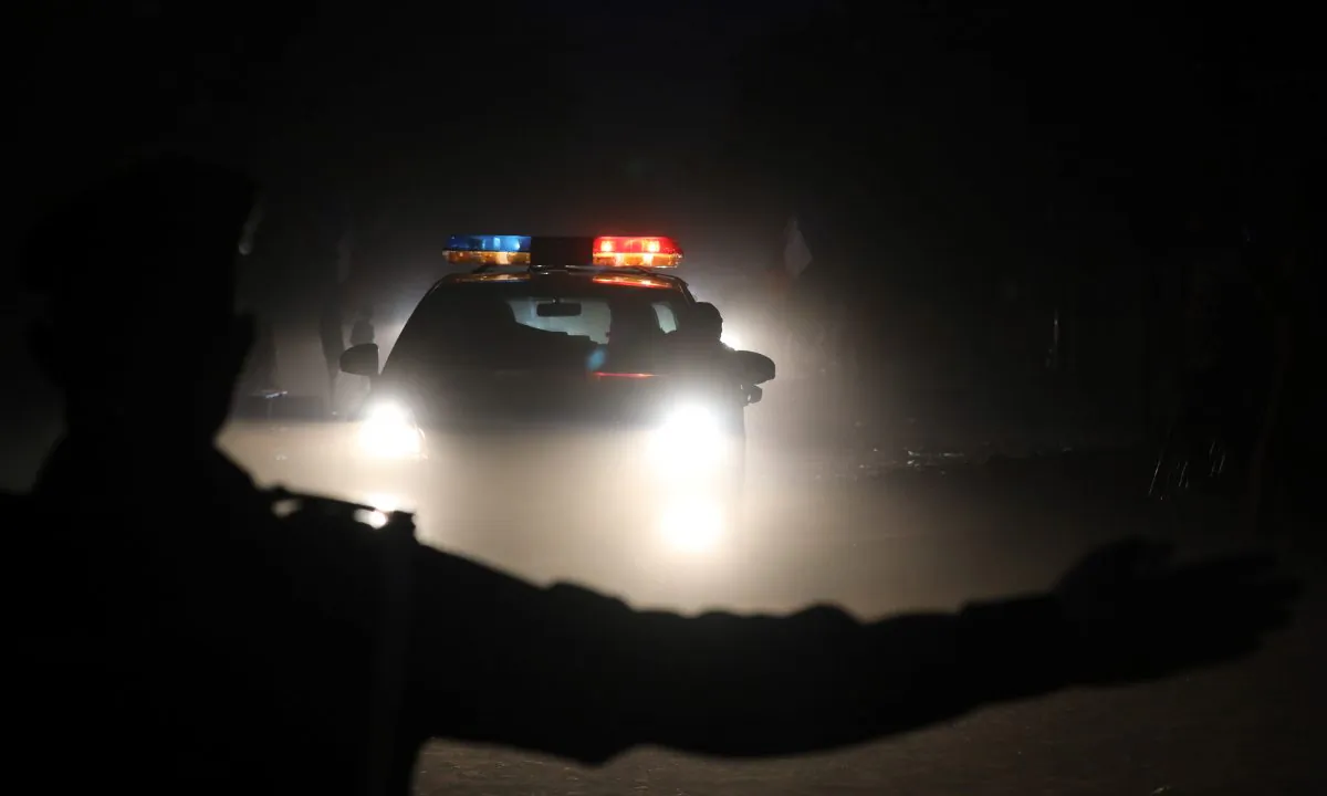 Silhouette of a police officer in front of a squad car. (Ludovic Marin/AFP/Getty Images)