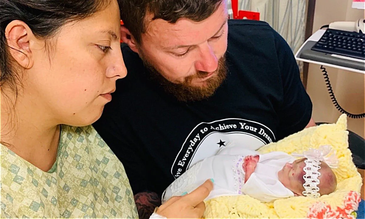 Parents, Jack and LeAndra Burcham with one of their triplets. (Jack N Lee Burcham/GoFundMe)